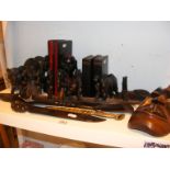 A quantity of wooden tribal items to include shoe horn, book ends, mask etc.