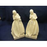 Two plaster figures depicting lady holding dog