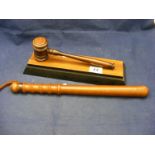 A wooden truncheon together with a gavel on a stand