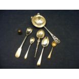 A quantity of silver items to include spoons, tea strainer and thimble etc.
