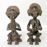 2 Partnerfiguren aus Holz. AFRIKA, 20. Jh. 1 männliche und 1 weibliche Figur, sitzend dargestellt, H
