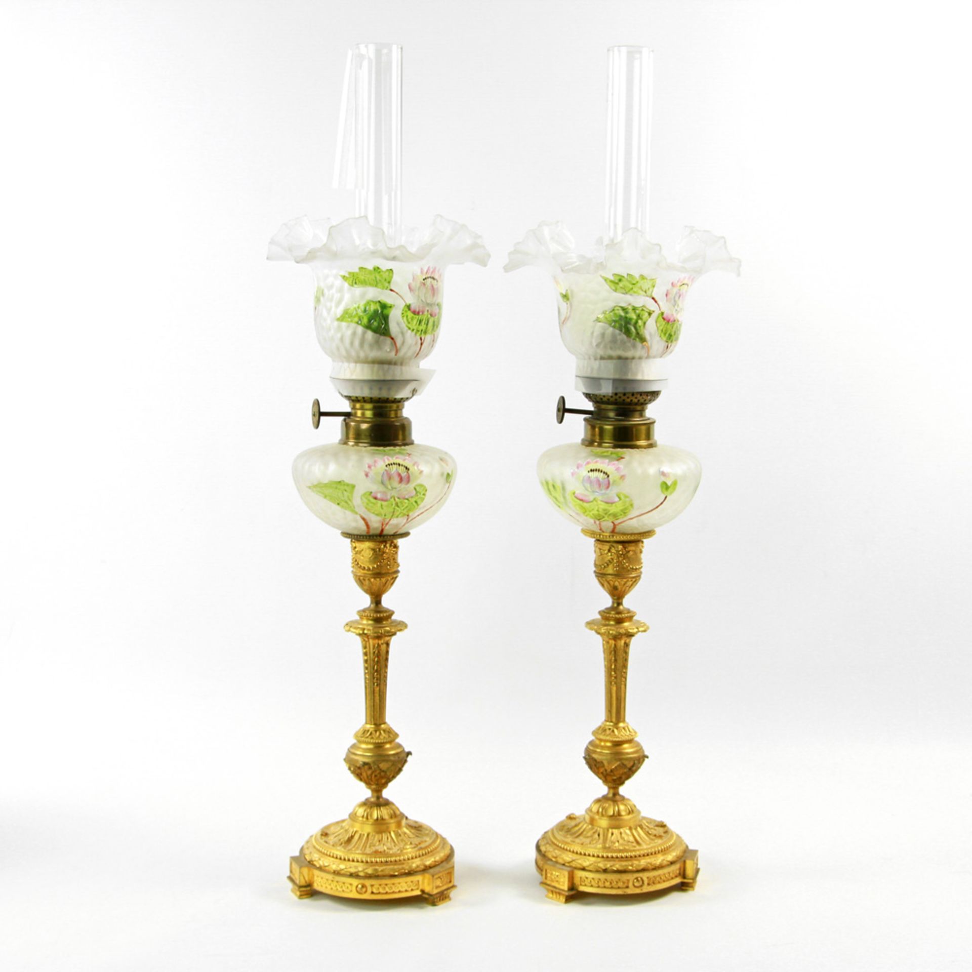 Paar Öllampen, Messing/ Glas, wohl 19./ 20. Jh. Mit Reliefdekor reich dekorierter Fuß, Ölbehälter