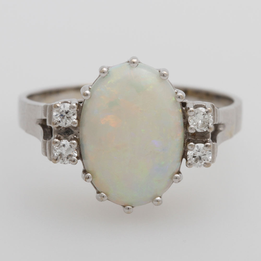 Opening: 270 EUR        Damenring mit weißem Opal und 4 kl. Brillanten. WG 14K, Brill. zus. ca. 0,