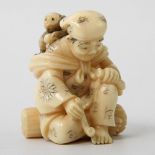 Netsuke eines Affendomteurs. JAPAN, 1. Hälfte 20. Jh. Pfeife rauchend und auf einem Baumstamm