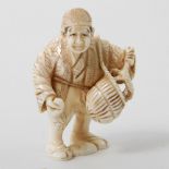 Netsuke eines Muschelverkäufers aus Elfenbein. JAPAN, 1. Hälfte 20. Jh. mit Korb, in einer Hand eine