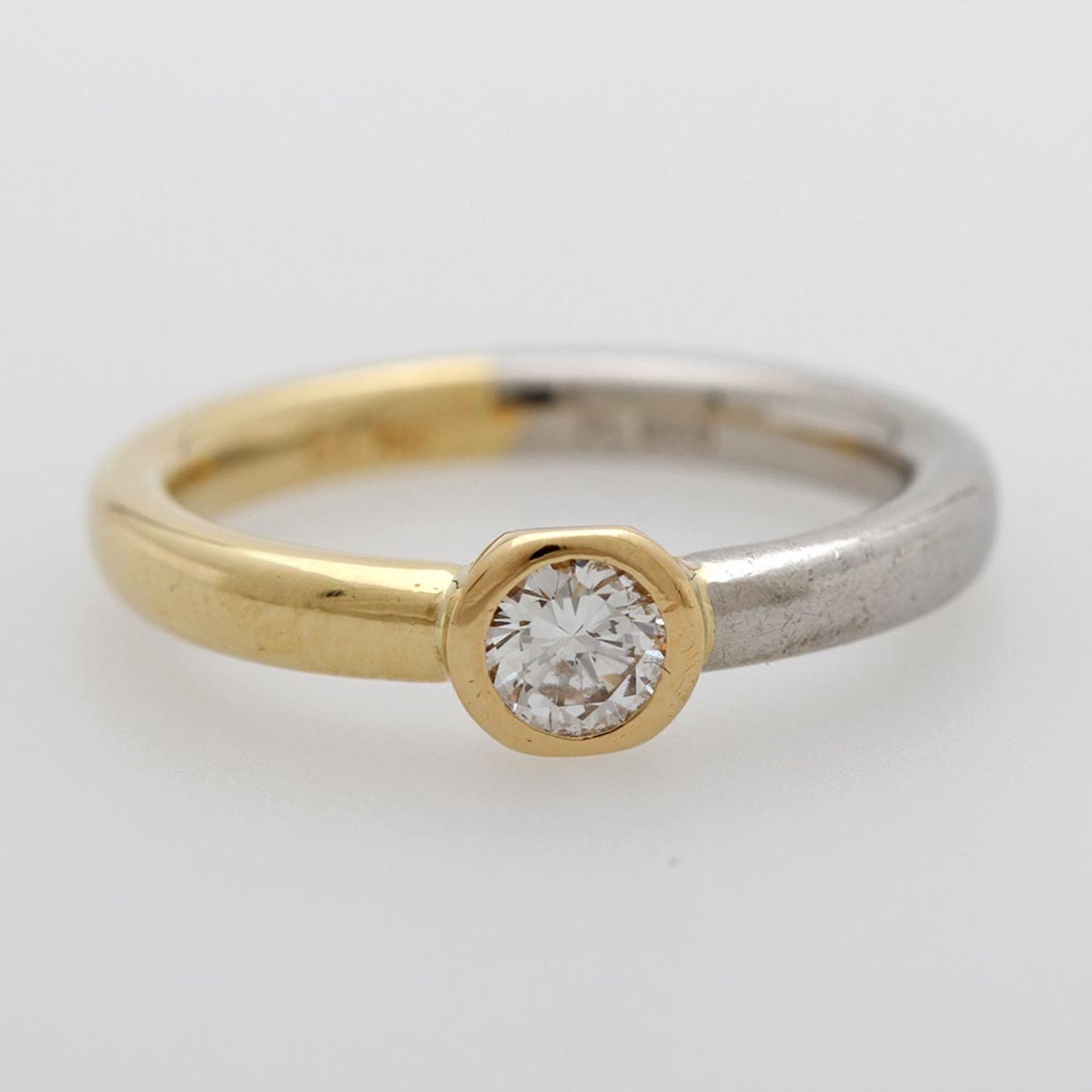 Solitärring in Bicolor besetzt mit einem Diam.-Brillant ca. 0,21ct FEINES WEIß/ VS-SI. GG 18K,