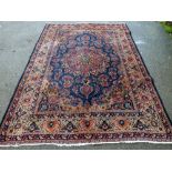 Tabriz blue ground carpet with central shaped cartouche and floral motifs throughout, 113" x 79"