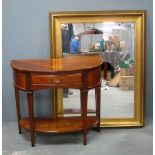 Yew demi lune two tiered inlaid side table with single drawer and a gilt framed wall mirror