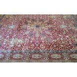 Large Persian red ground carpet with central shaped medallion and floral motifs, with multiple