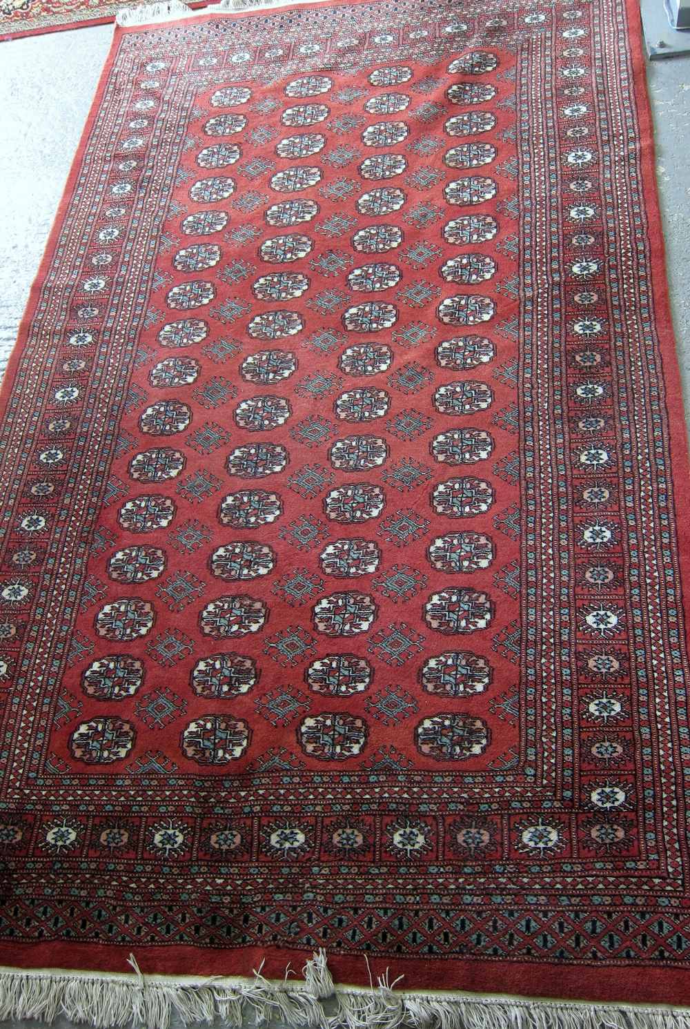 Afghan red ground rug with repeating medallions 250cm x 152cm