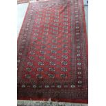 Afghan red ground rug with repeating medallions 250cm x 152cm