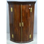 19th century mahogany wall hanging bowfronted corner cupboard, the two doors revealing shelves