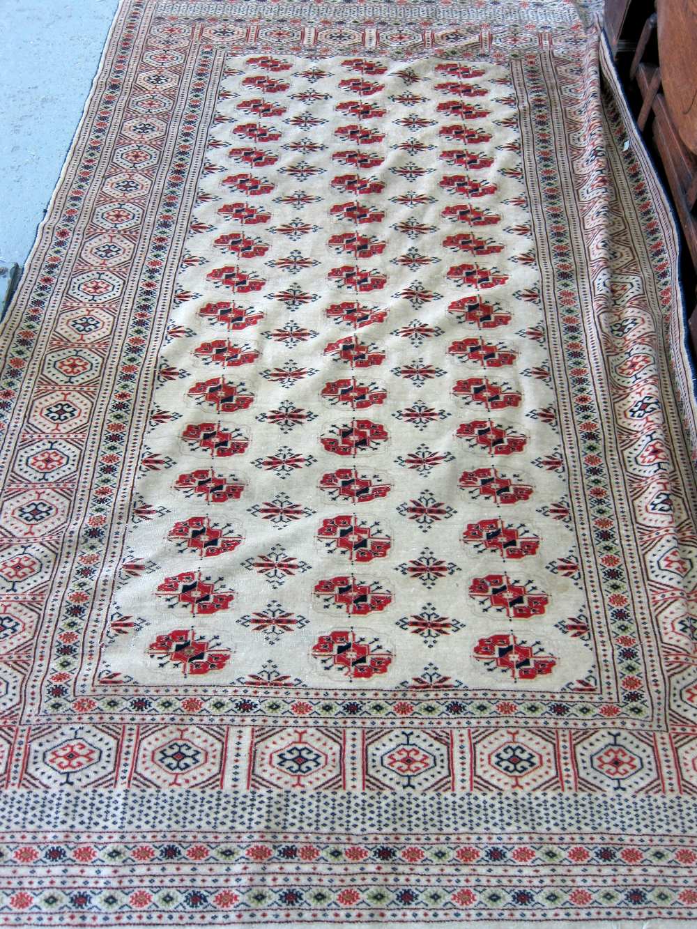 Afghan cream ground rug with repeating medallions and a Persian cream ground rug with central shaped