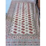 Afghan cream ground rug with repeating medallions and a Persian cream ground rug with central shaped