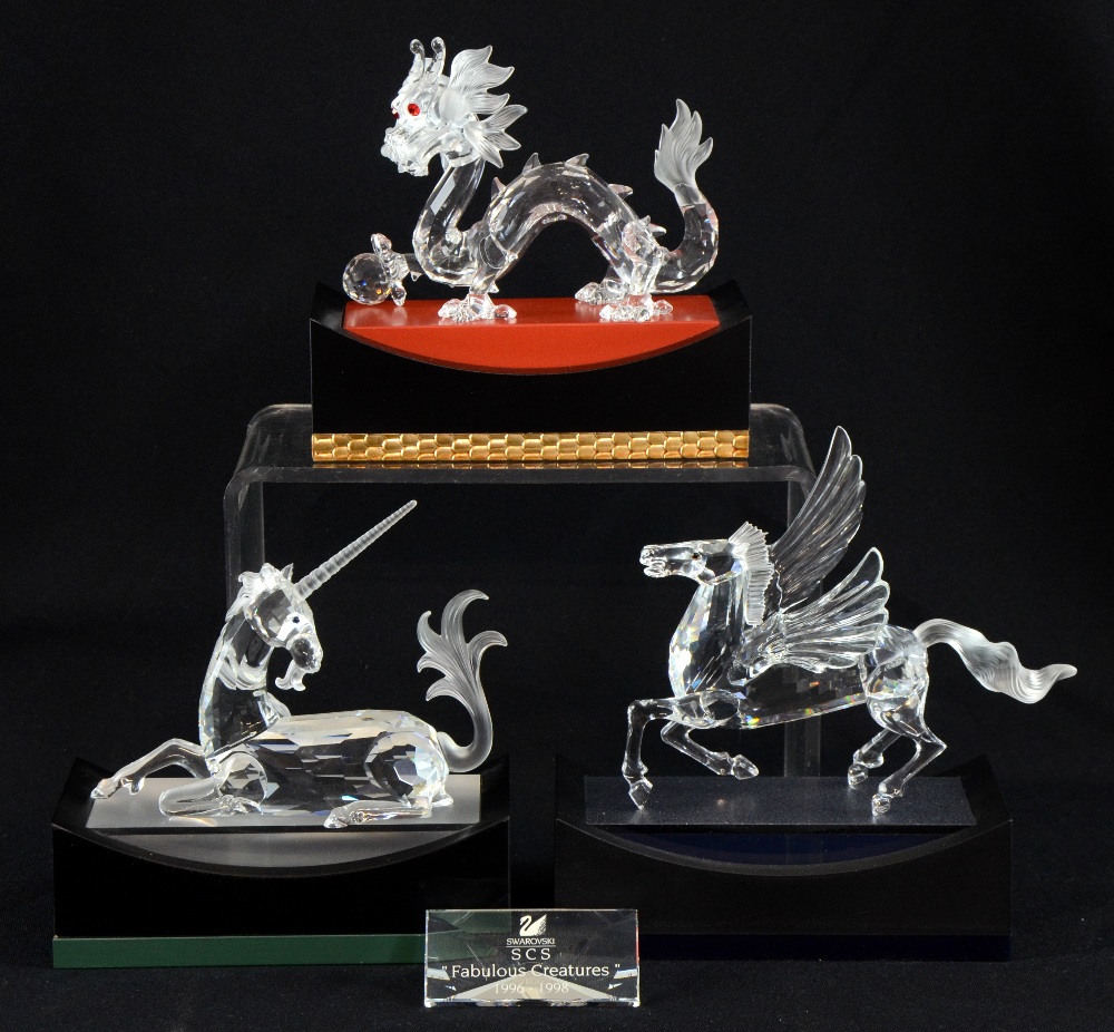 Swarovski crystal fabulous creatures, dragon, unicorn and Pegasus with stands and collectors plaque.