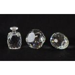 Three Swarovski clear crystal paperweights, one in the shape of an egg one in a geometric shape