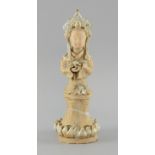 Chinese biscuit figure of a female standing on a lotus throne holding a pearl in her left hand, some