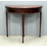 Mahogany demi lune card table, on square tapering legs to spade feet
