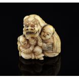 Carved Ivory Netsuke of 'The Lion festival Dog' with two attendants signedGood condition overall