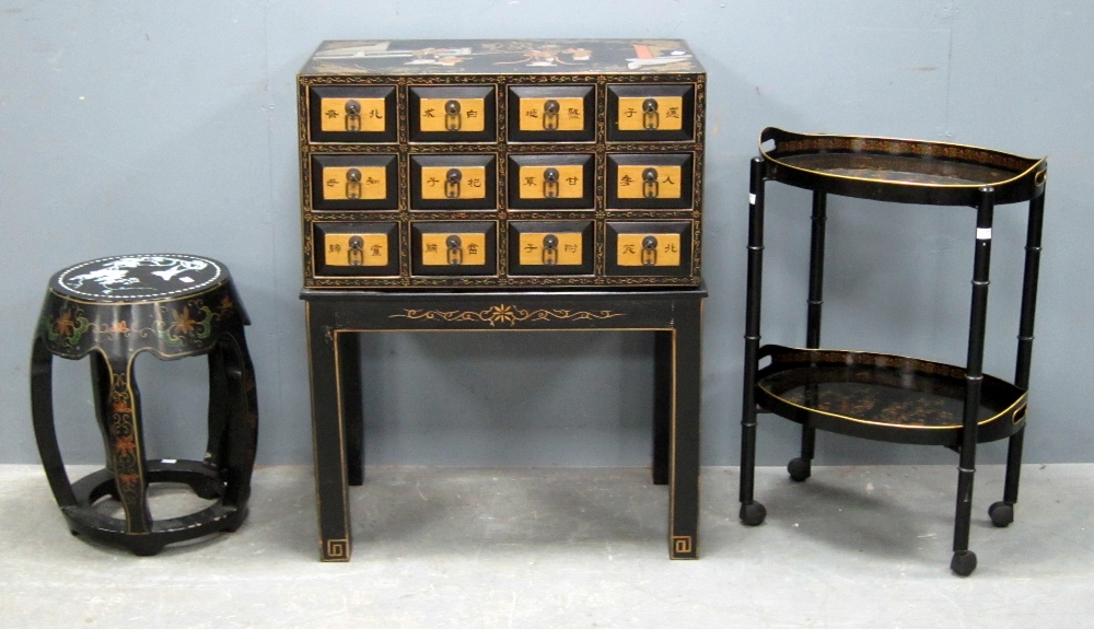 Black lacquered storage chest on stand decorated in the Japanese manner, similar decorated trolley
