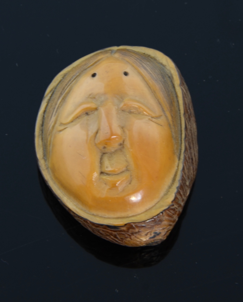 A Japanese boxwood Netsuke carved like a walnut of 'The Blind Masseuse' signed