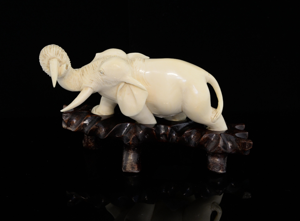 Japanese carved ivory elephant in a walking pose, with a tusk in it's trunk, on hardwood base, - Image 2 of 6