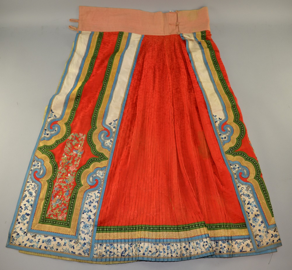 19th C Chinese male skirt, of brocaded red silk, pleated on the reverse, front appliqu‚d with