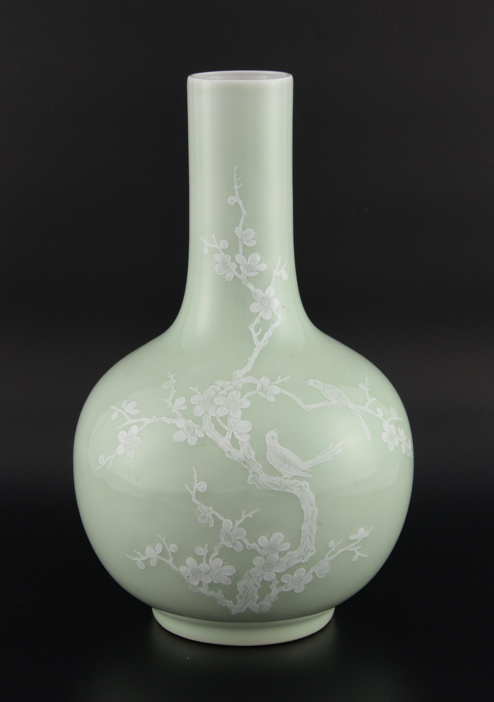 Chinese porcelain bottle vase, the pale celadon ground enamelled in white with two birds in a prunus