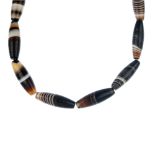 An agate bead necklace and loose bead, the necklace designed as a series of sixteen banded agate