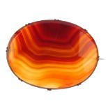 A banded agate brooch, of oval-shape outline the banded agate panel, to the plain mount. Length 7.