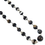 An early 20th century banded agate and glass bead single-strand necklace, comprising a graduated