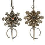 A white metal cloak pin set, designed as two scroll panels with gem-set central detail, to the