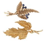 Two foliate brooches. To include a 9ct gold sapphire and colourless paste brooch and a textured