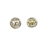 A pair of old-cut diamond collet ear studs. Estimated total diamond weight 0.65ct, K-tinted