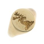 A 9ct gold seal ring. The oval-shape seal depicting a stags head, to the tapered shoulders and plain