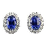 * A pair of sapphire and diamond cluster ear studs. Each designed as an oval-shape sapphire,