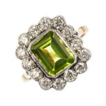 A peridot and diamond cluster ring. The rectangular-shape peridot, within a brilliant-cut diamond