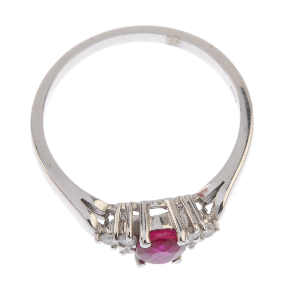 A ruby and diamond dress ring. The oval-shape ruby, to the brilliant-cut diamond trefoil shoulders - Image 2 of 2