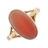 A hardstone ring. The oval sardonyx, within a collet setting, to the trifurcated shoulders and plain