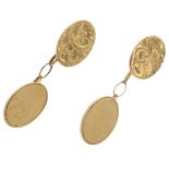 A pair of 9ct gold cufflinks. Each designed as two oval-shape panels, one with scroll engraving,