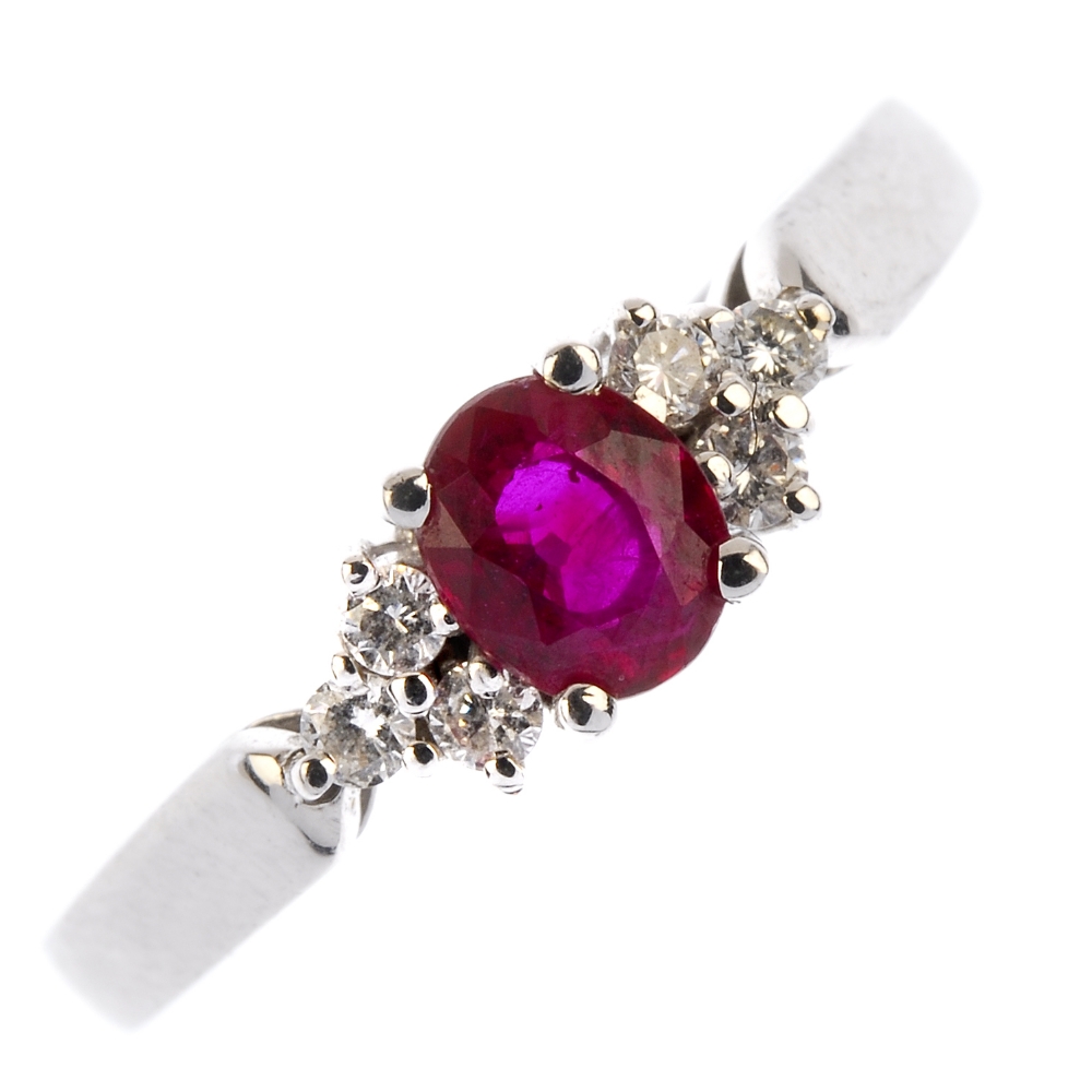 A ruby and diamond dress ring. The oval-shape ruby, to the brilliant-cut diamond trefoil shoulders