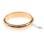 A hinged bangle. The curved front, to the similarly-designed reverse. Inner diameter 5.9cms.