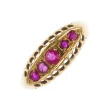 An early 20th century 18ct gold gem-set ring. The graduated red-gem line, to the openwork gallery