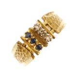 A 1970s 18ct gold diamond and sapphire dress ring. The single-cut diamond and circular-shape