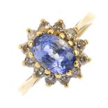 An 18ct gold sapphire and diamond cluster ring. The oval-shape sapphire, within a brilliant-cut