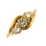 An 18ct gold diamond three-stone ring. The graduated brilliant-cut diamonds, to the asymmetric