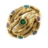 A gem-set ring. Of openwork bombe design, the textured foliate strands, with various circular-