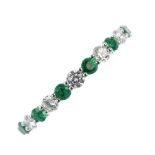 * An emerald and diamond half-circle eternity ring. The alternating circular-shape emerald and