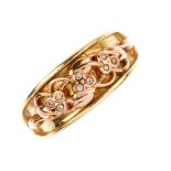 CLOGAU - a 9ct gold diamond ring. Of bi-colour design, the scrolling foliate motif, with brilliant-