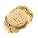 An early 20th century gold signet ring. The shield-shape front with initial monogram, to the grooved